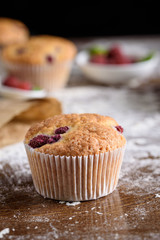 Delicious flavored cupcake with raspberries, white cream, and chocolate icing.