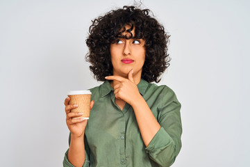 Young arab woman with curly hair drinking cup of coffee over isolated white background serious face thinking about question, very confused idea
