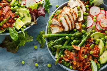 Cobb salad bowl with grilled chicken breast, asparagus, avocado, radishes and bacon