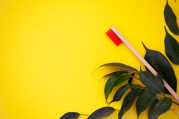 Eco bamboo toothbrush, organic on a yellow background, colored bristles, top view, top view. The...