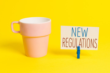 Word writing text New Regulations question. Business photo showcasing rules made government order to control way something is done Cup empty paper blue clothespin rectangle shaped reminder yellow