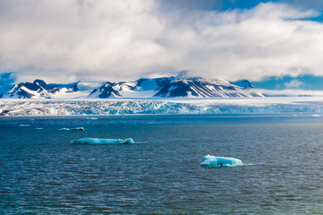 The end of a glacier in the Arctic Circle where it falls into the Arctic Ocean in Hornsund,...