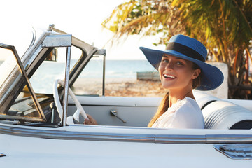 Happy young woman and retro convertible car
