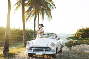 Happy young woman and retro convertible car