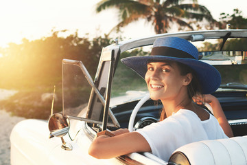 Happy young woman and retro convertible car