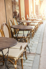 Empty tables in between dining hours. Old fashioned cafe terrace in a summer day