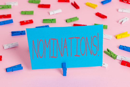 Writing note showing Nominations. Business concept for action of nominating or state being nominated for prize Colored clothespin papers empty reminder pink floor office pin