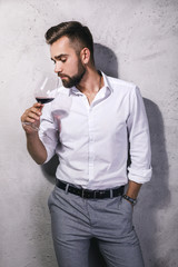 Handsome bearded man is tasting red wine