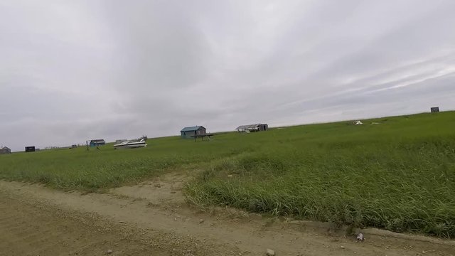 Passenger POV while driving of remote wooden cabins and native fish camps in the wilderness. Nome, Alaska.