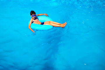 top view boy in the pool on an rubber ring, healthy lifestyle concept.