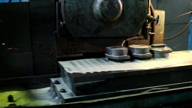 Processing of parts on an old lathe in a factory workshop.
