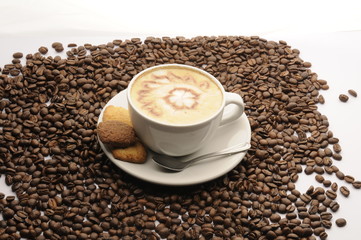 Taza de café con galletas y granos esparcidos