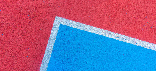 Colorful sports court background. Top view to red and blue field rubber ground with white lines...