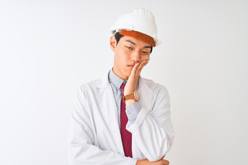 Chinese architect man wearing coat and helmet standing over isolated white background thinking looking tired and bored with depression problems with crossed arms.