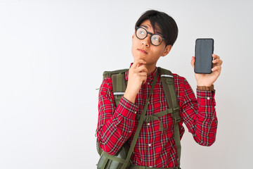 Chinese hiker man wearing canteen holding smartphone over isolated white background serious face...