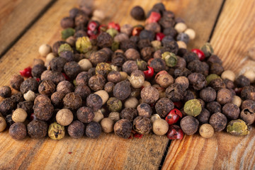 Tasty colorful pepper on a wooden kitchen table. Fresh spices used in home cooking.