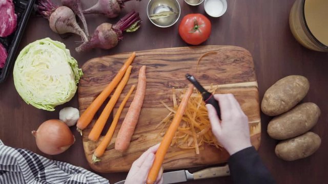 Step by step. Flat lay. Slicing orange carrots into the small cubes for beet soup, borscht.