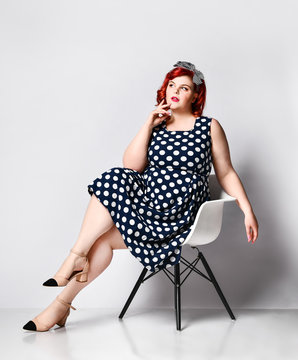 Pin up a female portrait. Beautiful retro fat woman in polka dot dress with red lips and old-style haircut