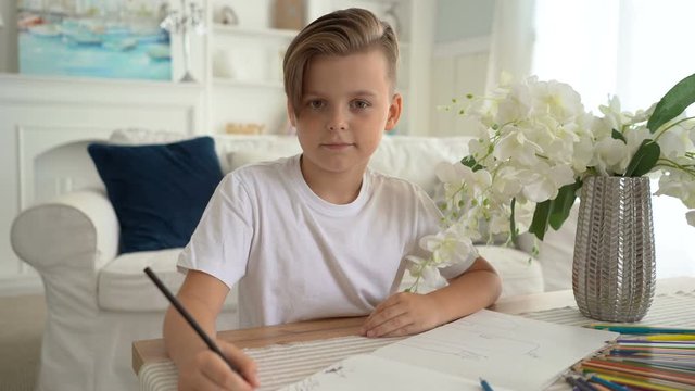 Boy drawing at home sitting on a on the floor