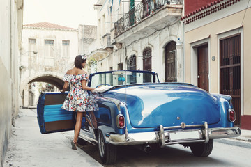 Woman wearing beautiful dress and retro convertible car