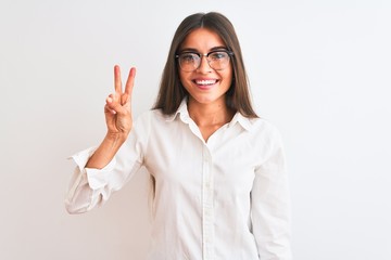 Young beautiful businesswoman wearing glasses standing over isolated white background showing and pointing up with fingers number two while smiling confident and happy.