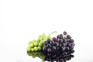 Two bunches of green and black grapes on a white background. Fresh Isolated Grapes