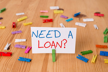 Text sign showing Need A Loan question. Business photo text amount of money that is borrowed often from bank Colored clothespin papers empty reminder wooden floor background office