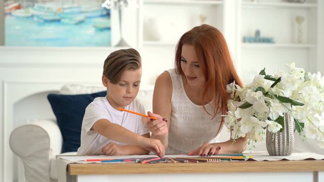 Mom shares with pencils with her son then they drawing together.