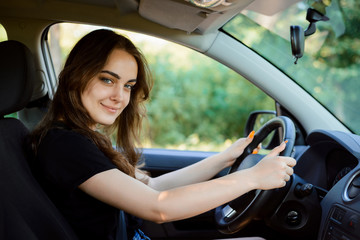 Naklejka na ściany i meble Portrait of beautiful young woman in the new car