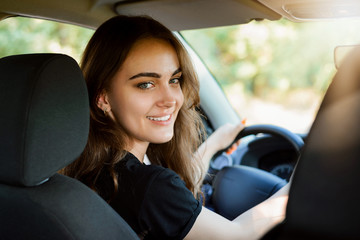 Happy tenage girl in her first new car after receiving driving licence