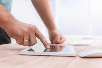 close up. a young man uses a digital tablet in the office