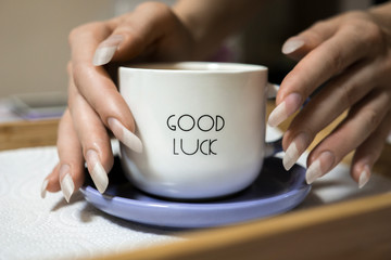 Woman hands with long natural nails holding cup of coffee