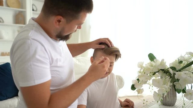 Father's Day. Father doing modern hairstyle of his son.