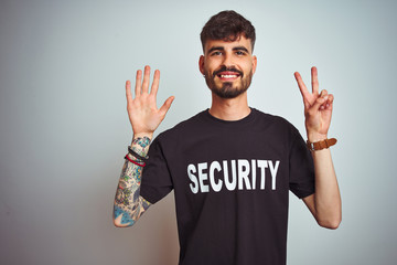 Young safeguard man with tattoo wering security uniform over isolated white background showing and...