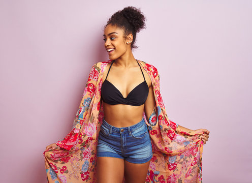 Young beautiful african american woman on vacation standing wearing bikini and colorful caftan