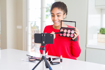 Young african american influencer woman recording make up tutorial with a happy face standing and smiling with a confident smile showing teeth