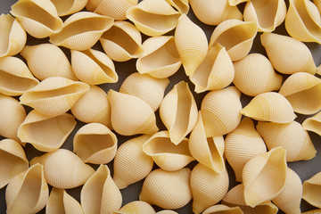 Conchiglie rigate raw pasta on gray background, Flat Lay