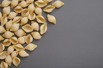Conchiglie rigate raw pasta on gray background, Flat Lay with Copy Space
