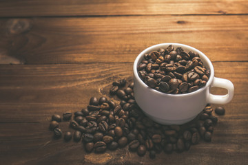 Cup with coffee grains on wooden table