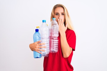 Young beautiful woman recycling plastic bottles standing over isolated white background cover mouth...