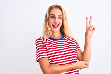 Fototapeta premium Young beautiful woman wearing red striped t-shirt standing over isolated white background smiling with happy face winking at the camera doing victory sign. Number two.