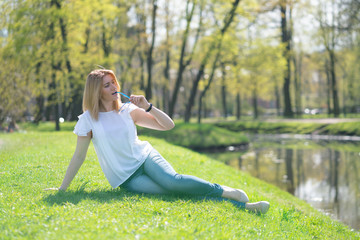 Naklejka na ściany i meble pretty woman relaxing by walking in the city park in jeans outfit