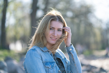cute happy caucasian blonde girl with bob haircut in the city park outdoor