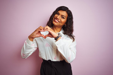 Transsexual transgender businesswoman standing over isolated pink background smiling in love doing heart symbol shape with hands. Romantic concept.