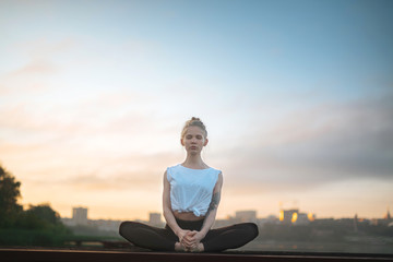 Girl practice yoga early morning on pier