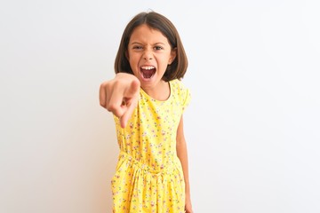 Young beautiful child girl wearing yellow floral dress standing over isolated white background...