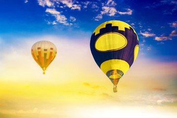 Hot air balloons fly in sunset sky against background