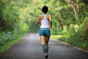 Zelfklevend Fotobehang Female runner running at summer park trail . Healthy fitness woman jogging outdoors. © lzf