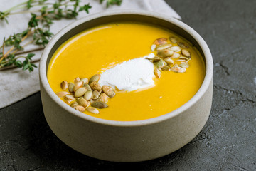 Soup cream of pumpkin on black concrete table