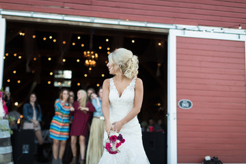 Young bride tossing bouquet at wedding reception